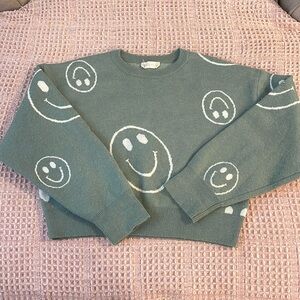 Green with white smiley faces sweater.